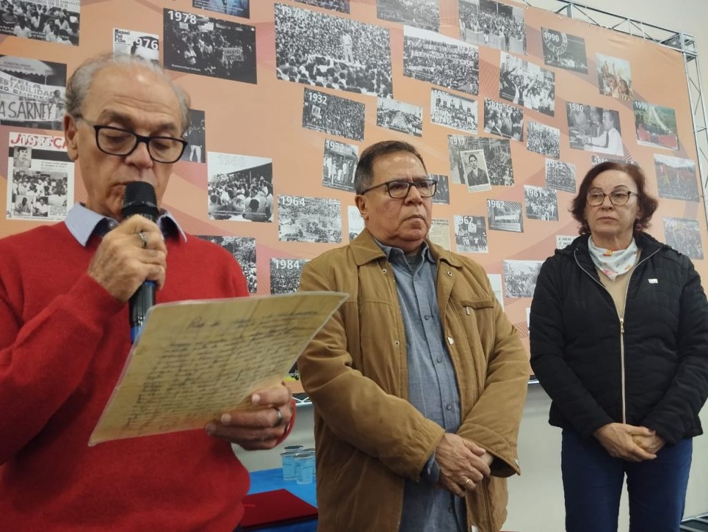 Clodsmidt Riani Filho lê carta que seu pai, o histórico sindicalista Riani, enviou à sua mãe, no momento em que sofreu repressão do golpe militar. Ao seu lado, João Carlos Juruna, da Força Sindical, e Márcia Viotto, da CTB.